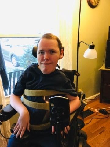 This is a photo of wheelchair user Ryan with a game controller joystick